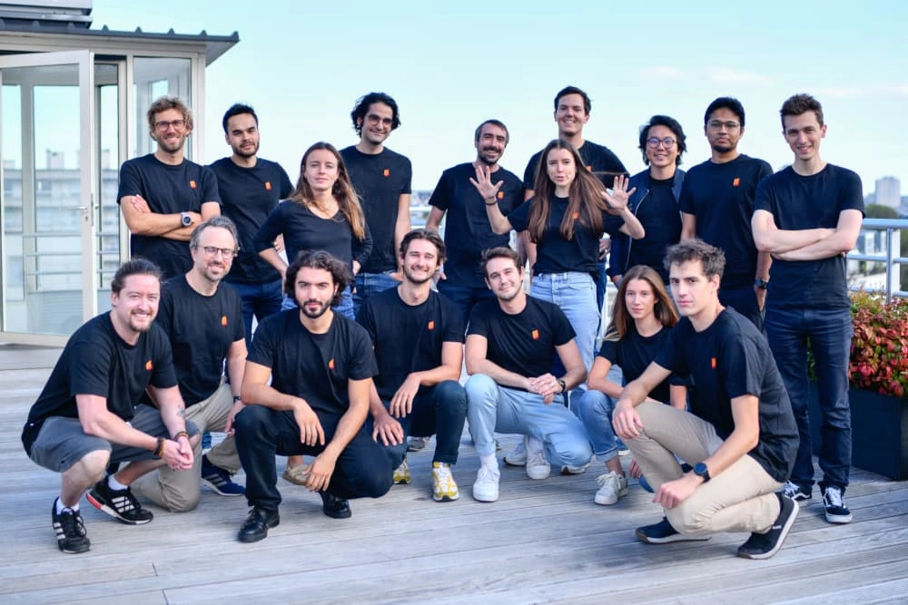 Group of people on a rooftop terrace, all wearing black shirts.