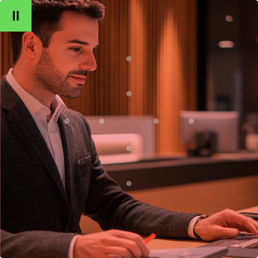 A man in a suit working at a desk in an office setting.