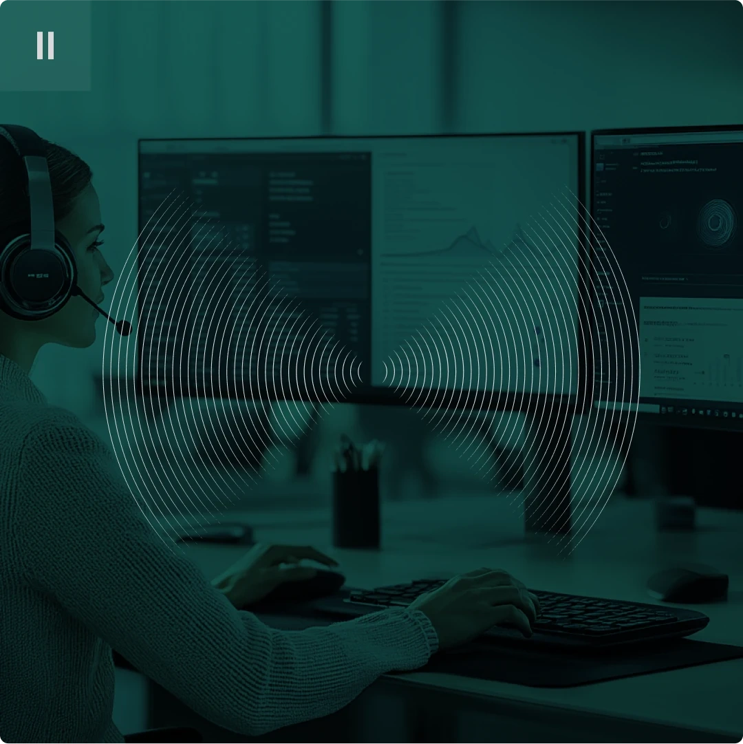 Person wearing a headset working at a computer with dual monitors, overlaid with sound wave graphics.