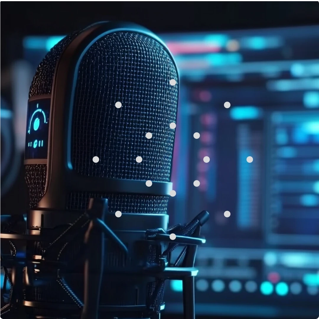 A close-up of a professional microphone in a recording studio with audio equipment in the background.