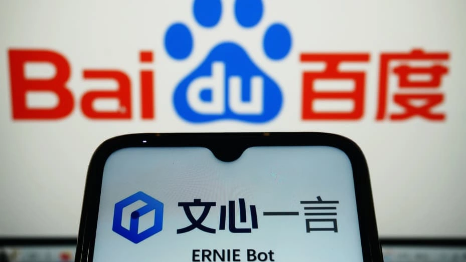 A smartphone screen displaying the ERNIE Bot interface in front of a Baidu logo on a computer monitor.